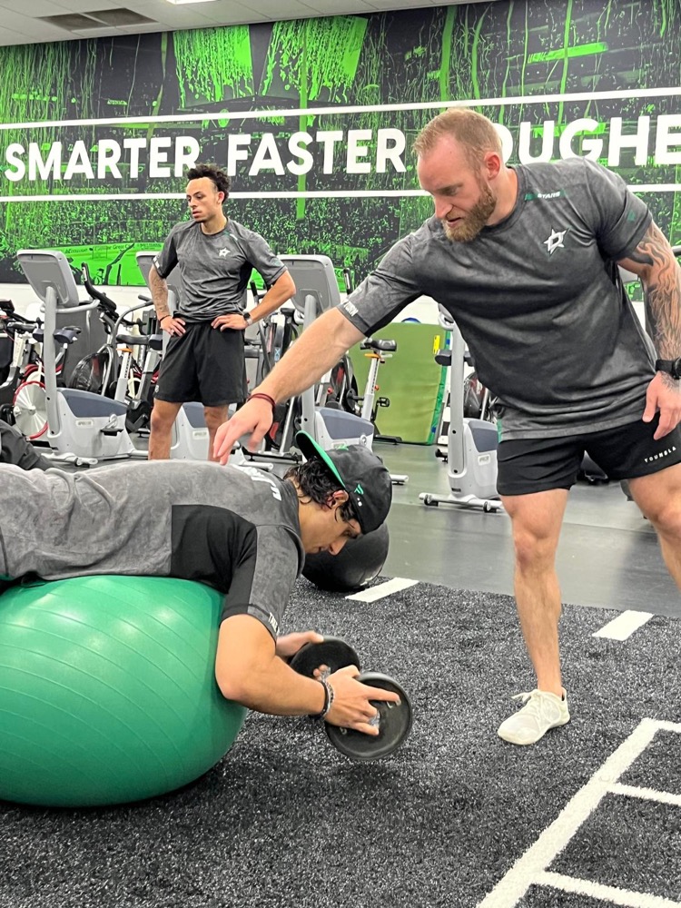 Jace coaching a Dallas Stars player on the training floor
